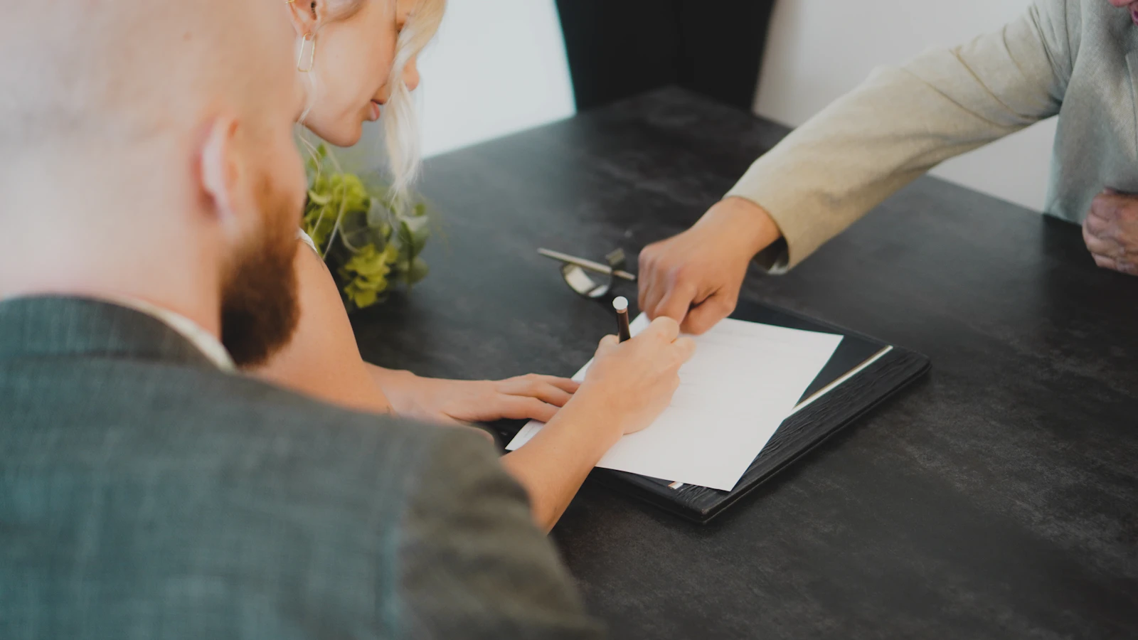 A couple signing a document together at a desk
