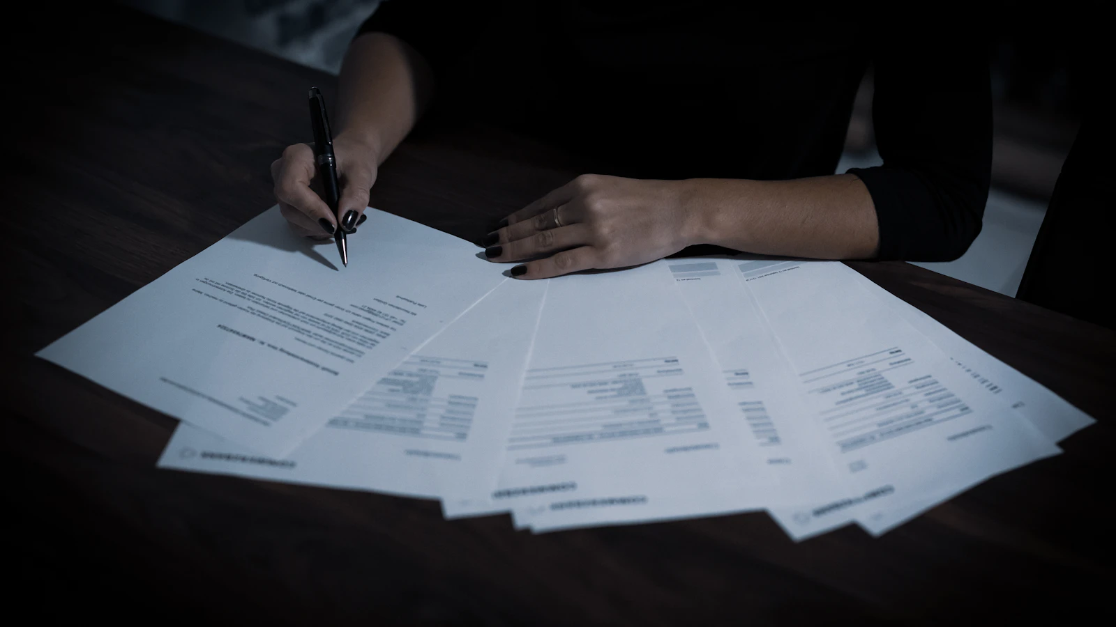 A woman sitting at a table with lots of papers