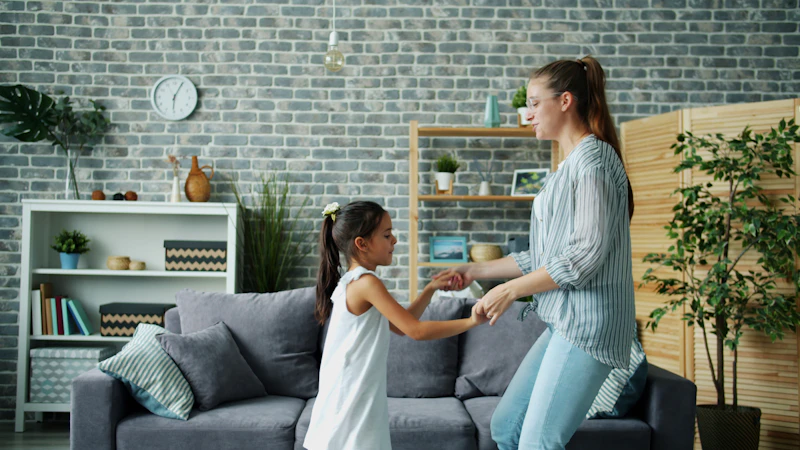 A mother and daughter dancing together in a living room