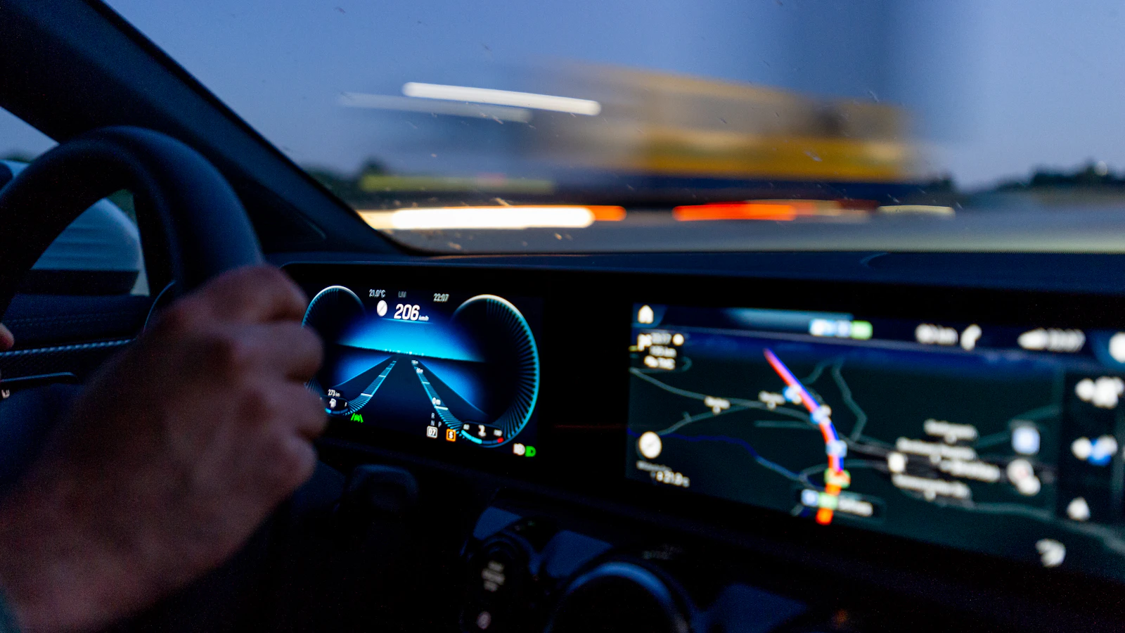 A driver's hand on a steering wheel